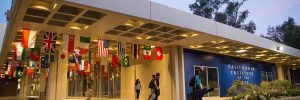 CalArts campus with international flags hanging from the overhang of the main entrance
